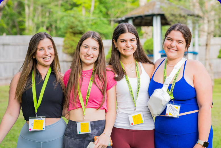 Un grupo variopinto de jóvenes que saltan de alegría en un frondoso jardín durante un evento comunitario.