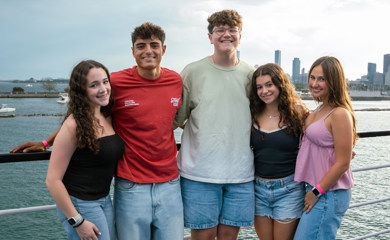 Grupo de tres padres sonrientes en un evento comunitario