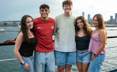 Un grupo de tres padres sonrientes en un evento comunitario