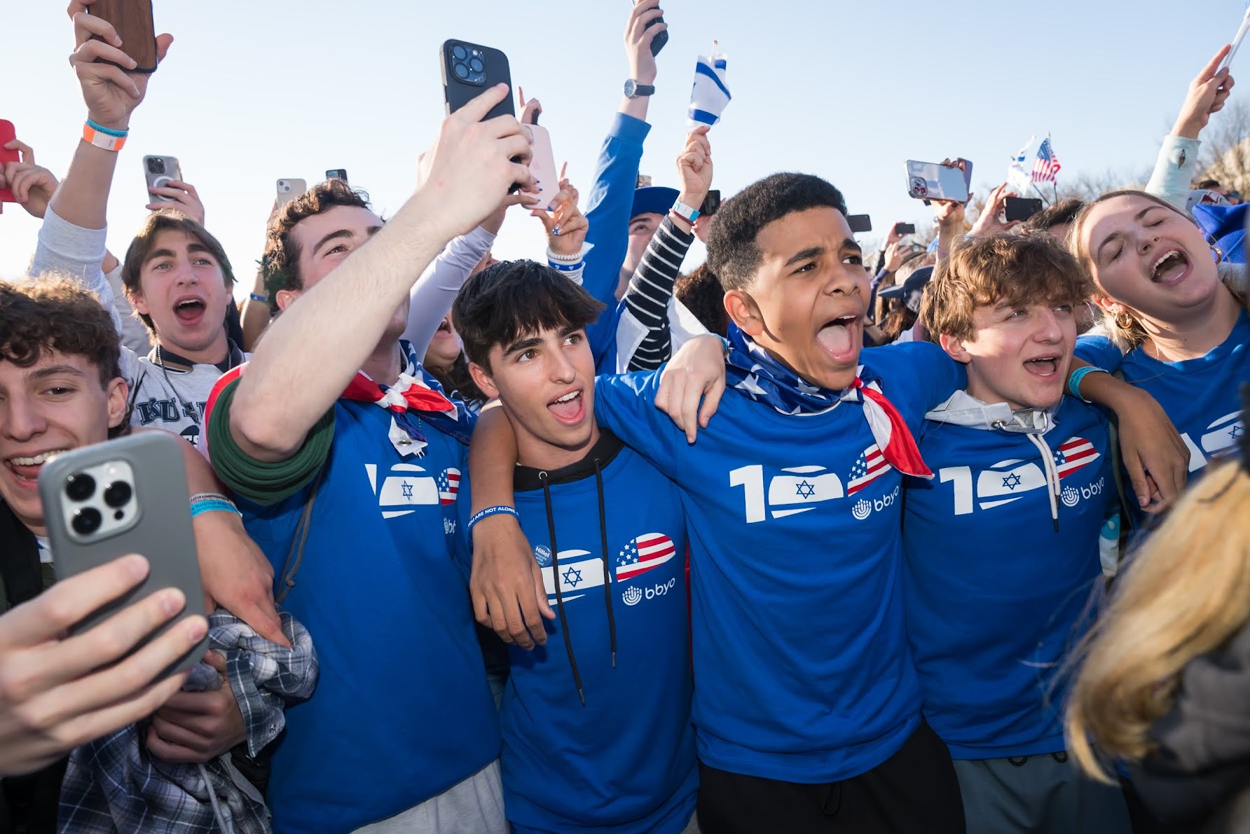 Un grupo de jóvenes de diferentes orígenes sonriendo en un evento comunitario