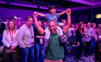 Un grupo de tres padres sonrientes en un evento comunitario
