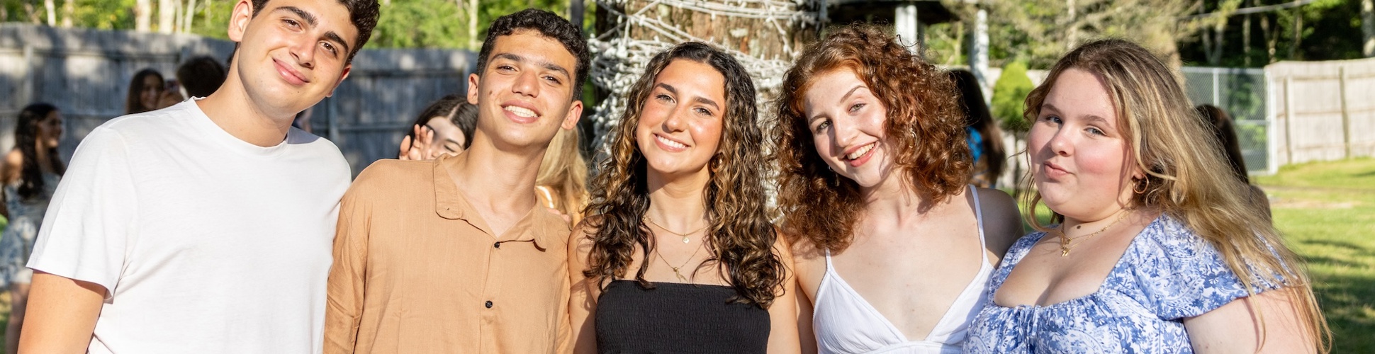 Un grupo de jóvenes de diferentes orígenes sonriendo en un evento comunitario