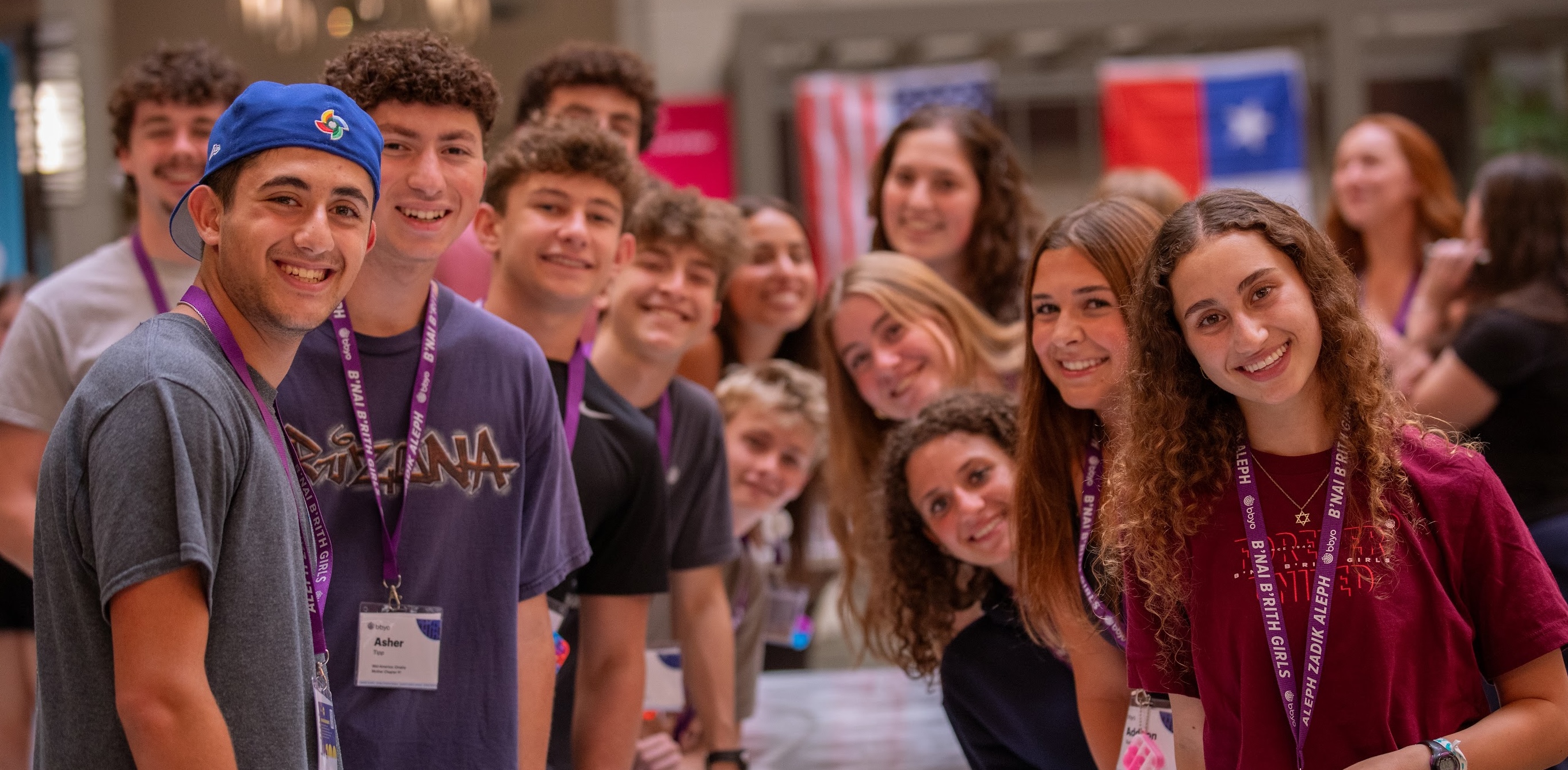 Un grupo de jóvenes de diferentes orígenes sonriendo en un evento comunitario