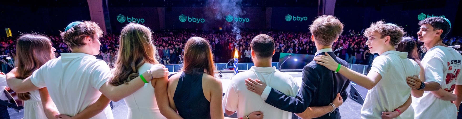 Un grupo de jóvenes de diferentes orígenes sonriendo en un evento comunitario