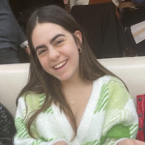 Un grupo variopinto de jóvenes que saltan de alegría en un frondoso jardín durante un evento comunitario.
