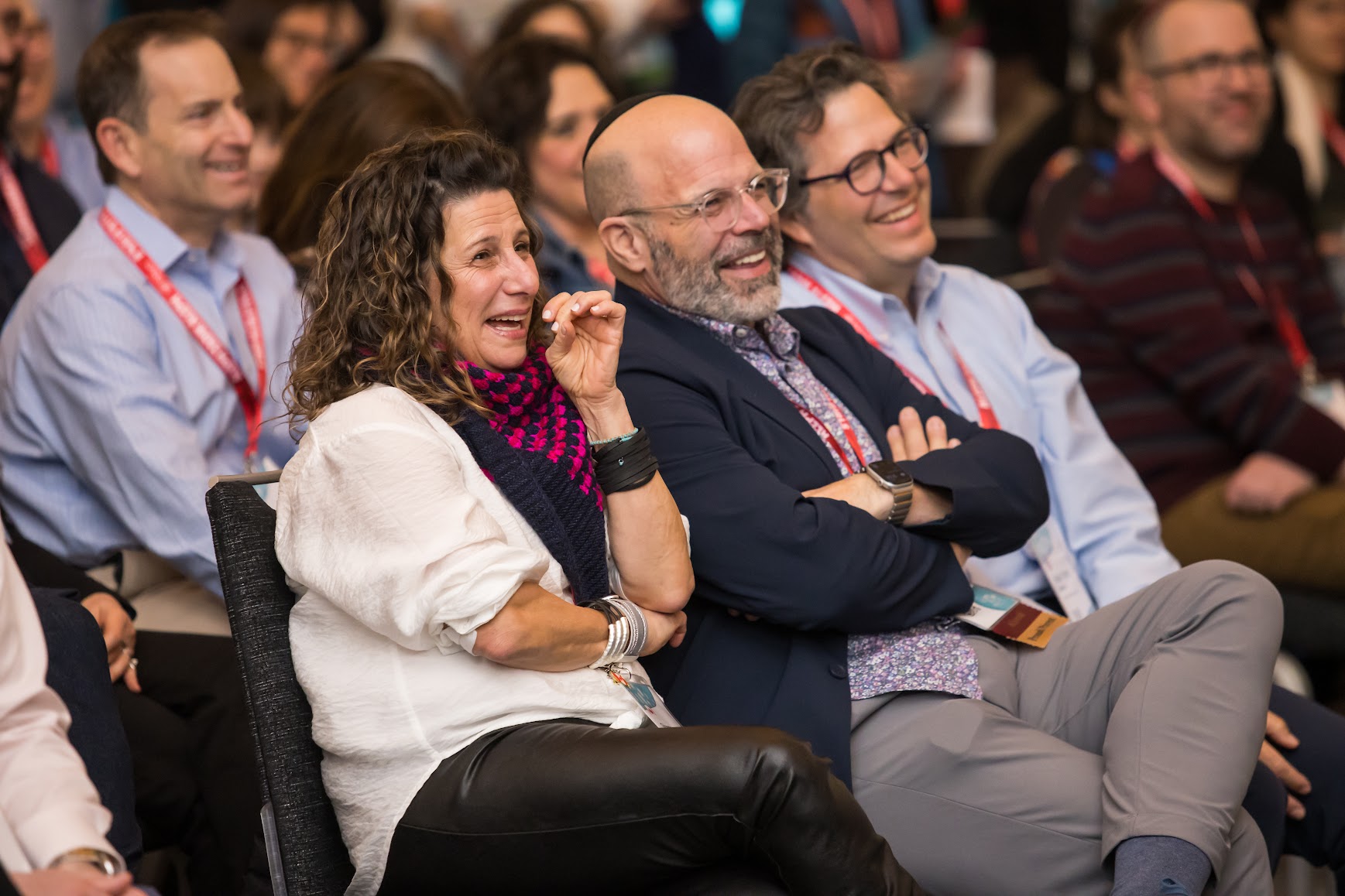 Un grupo de tres padres sonrientes en un evento comunitario
