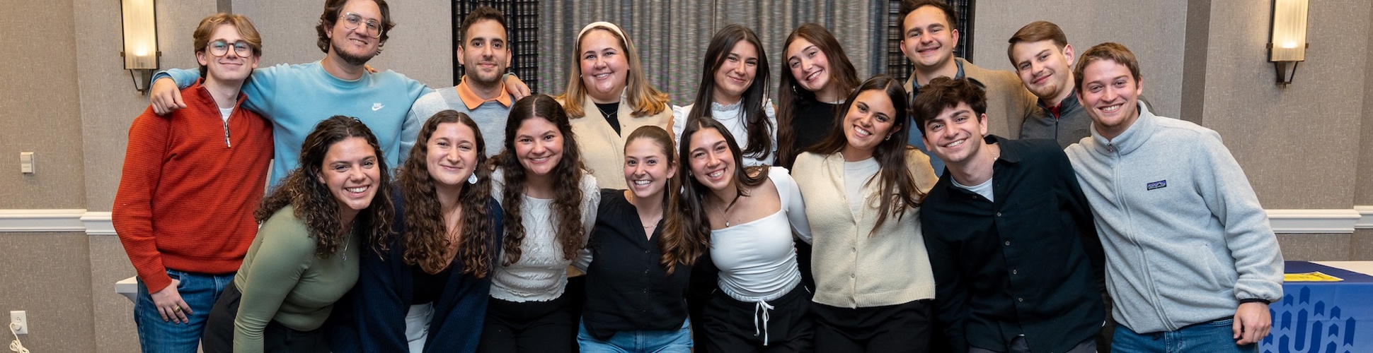 Un grupo de jóvenes de diferentes orígenes sonriendo en un evento comunitario