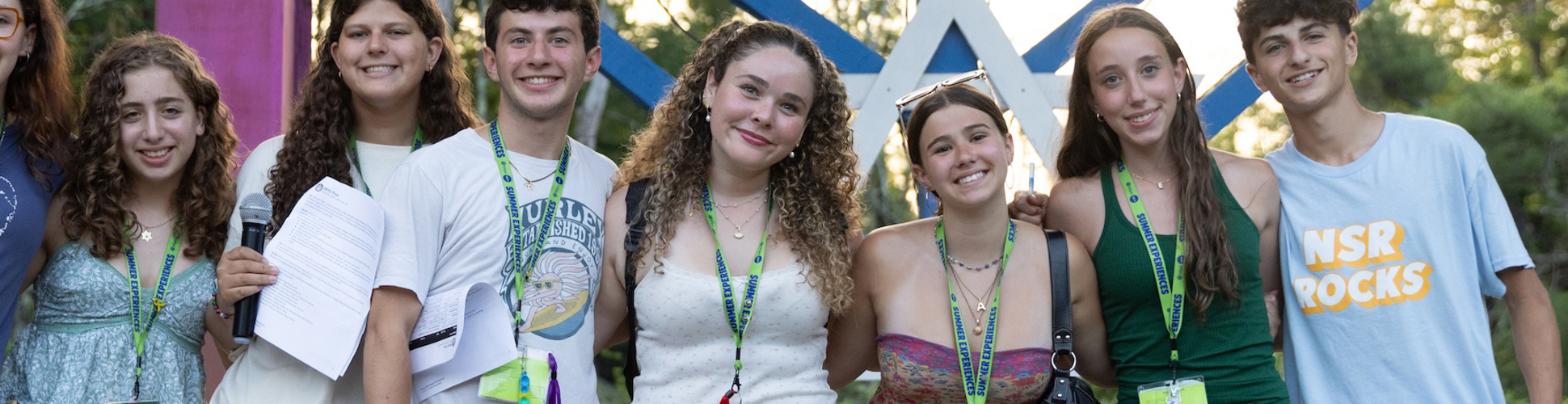 Un grupo de jóvenes de diferentes orígenes sonriendo en un evento comunitario