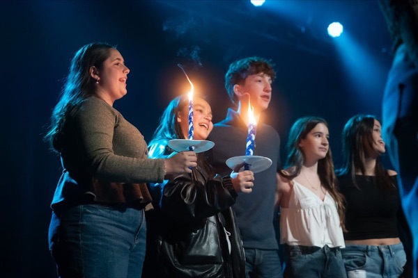 Celebración BBYO con confeti, luces y una multitud de asistentes