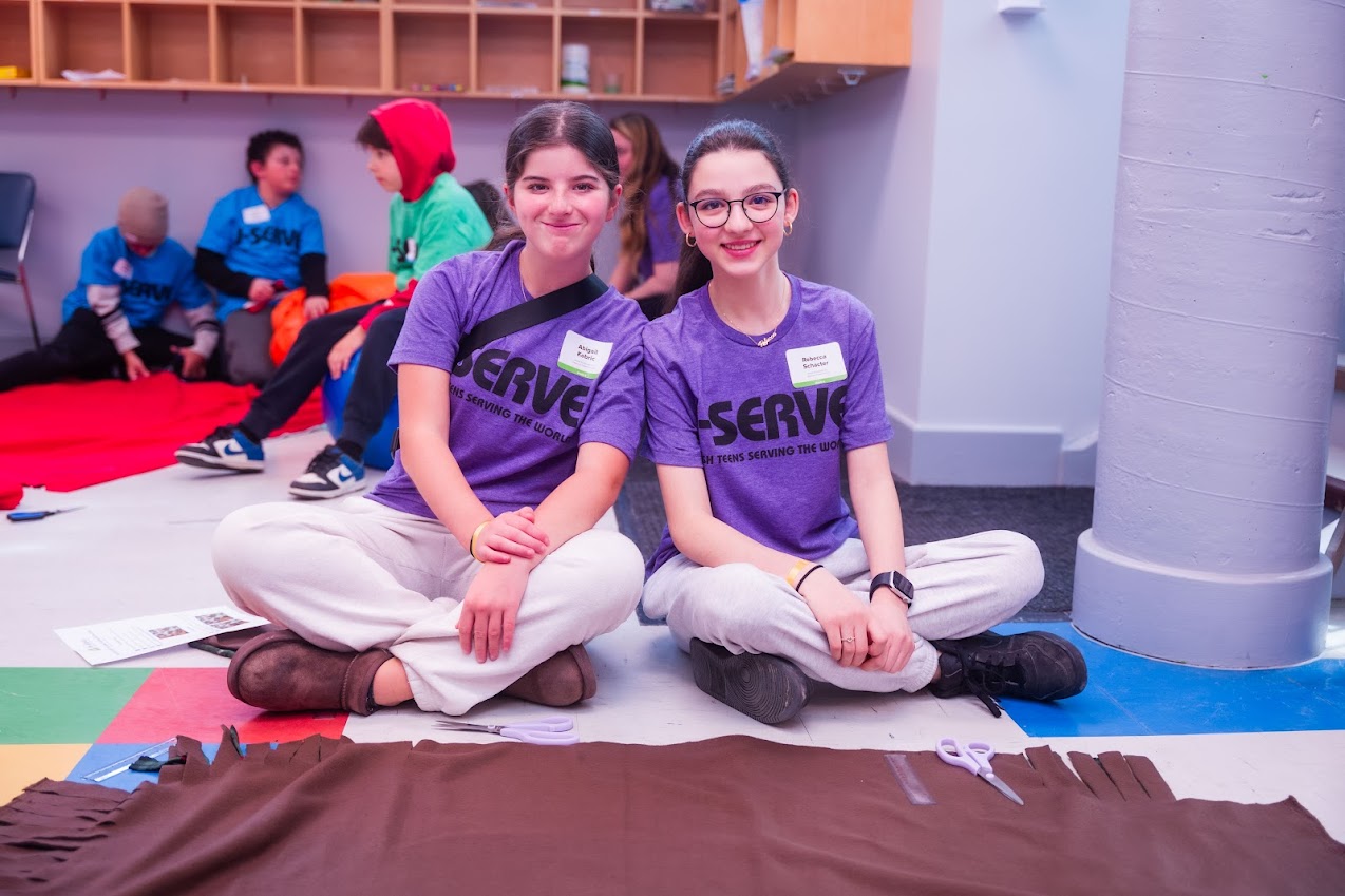 Un grupo de tres padres sonrientes en un evento comunitario