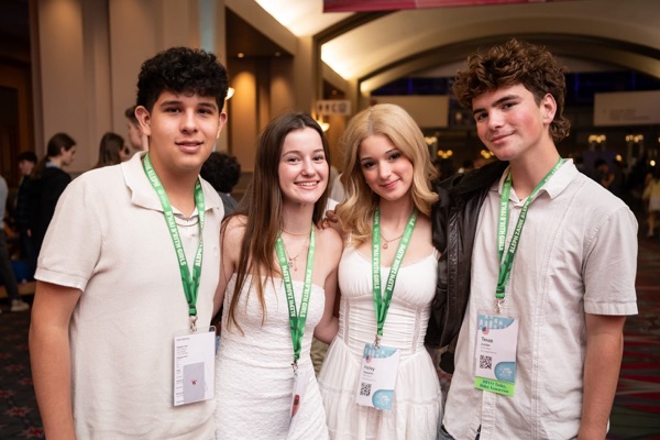 Un grupo de tres padres sonrientes en un evento comunitario