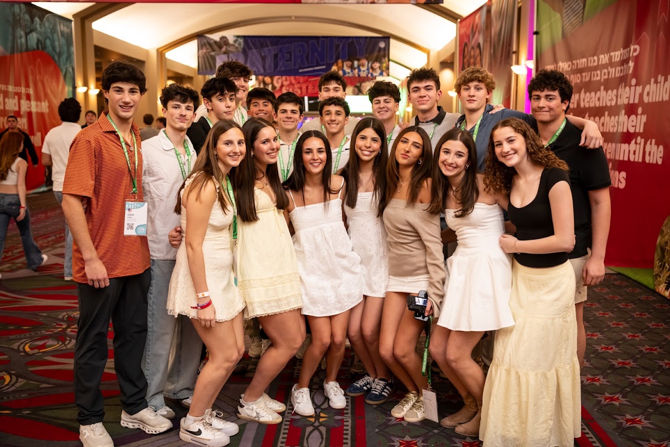 Un grupo de tres padres sonrientes en un evento comunitario