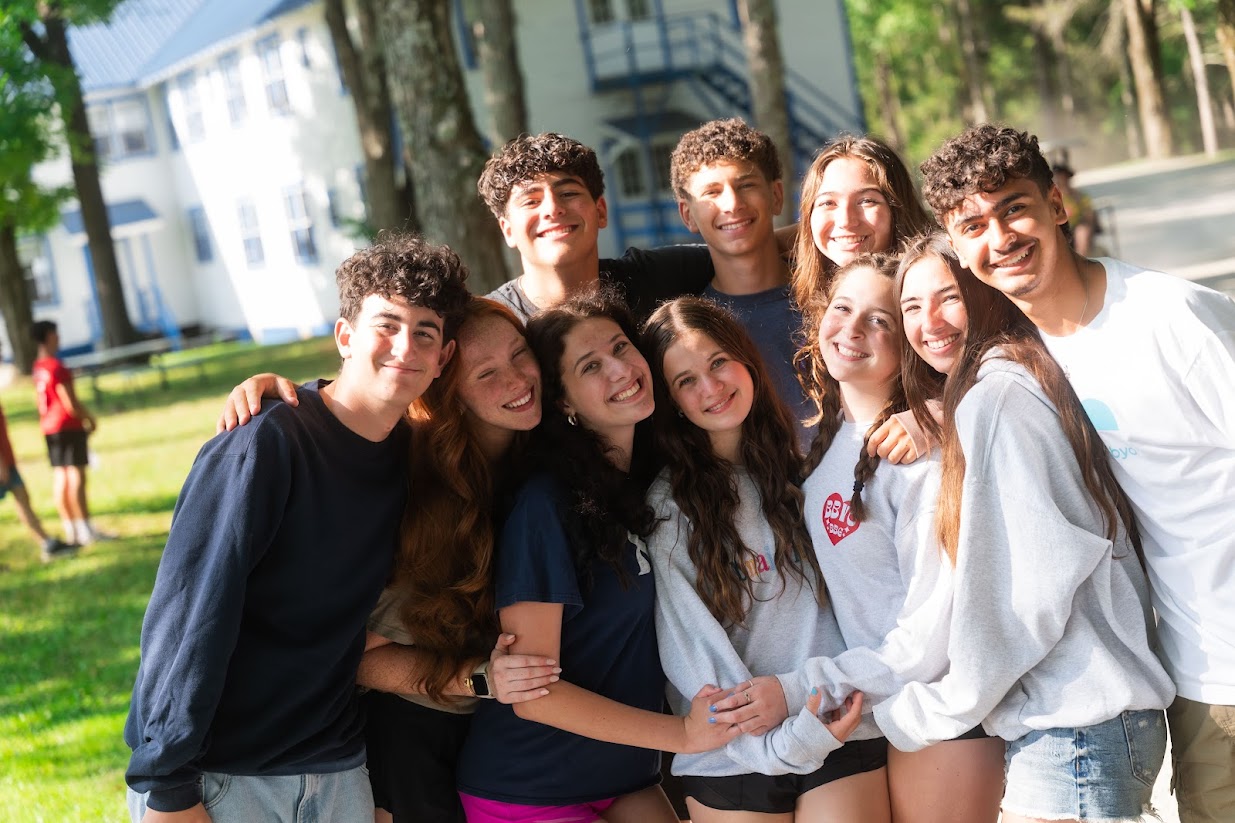 Un grupo de jóvenes de diferentes orígenes sonriendo en un evento comunitario