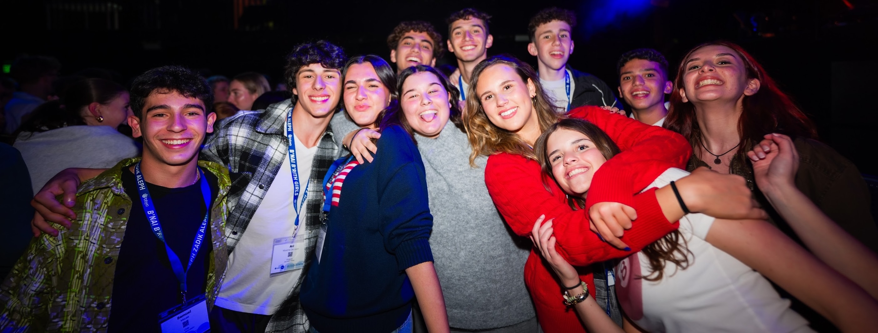 Un grupo de jóvenes de diferentes orígenes sonriendo en un evento comunitario