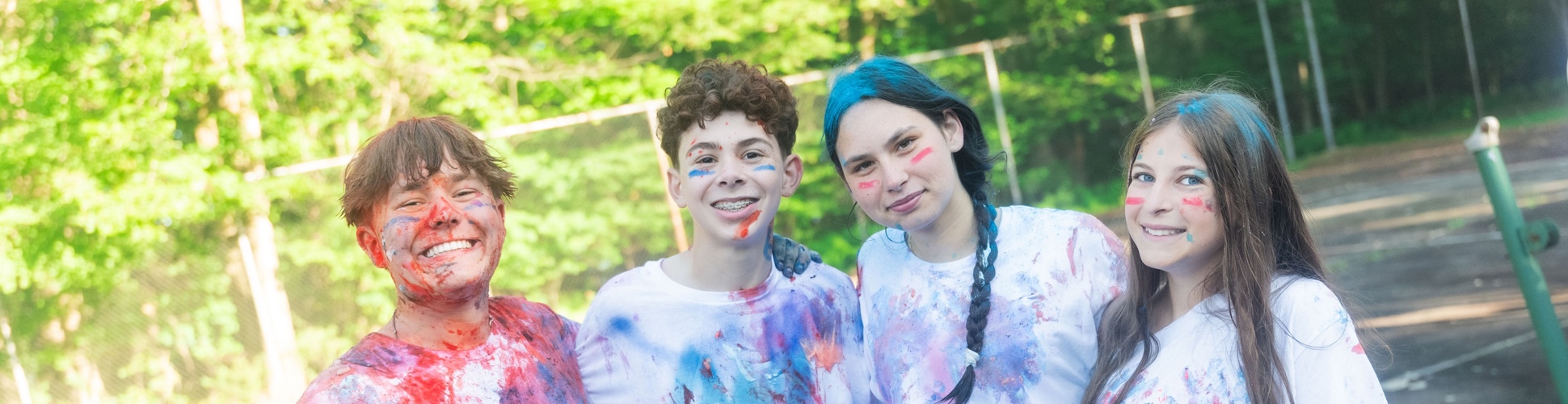 Un grupo de jóvenes de diferentes orígenes sonriendo en un evento comunitario