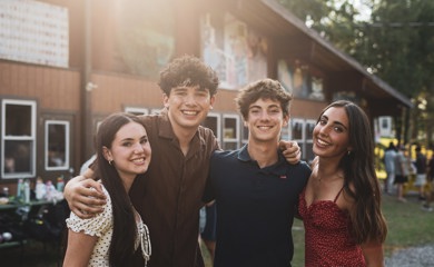 Grupo de tres padres sonrientes en un evento comunitario